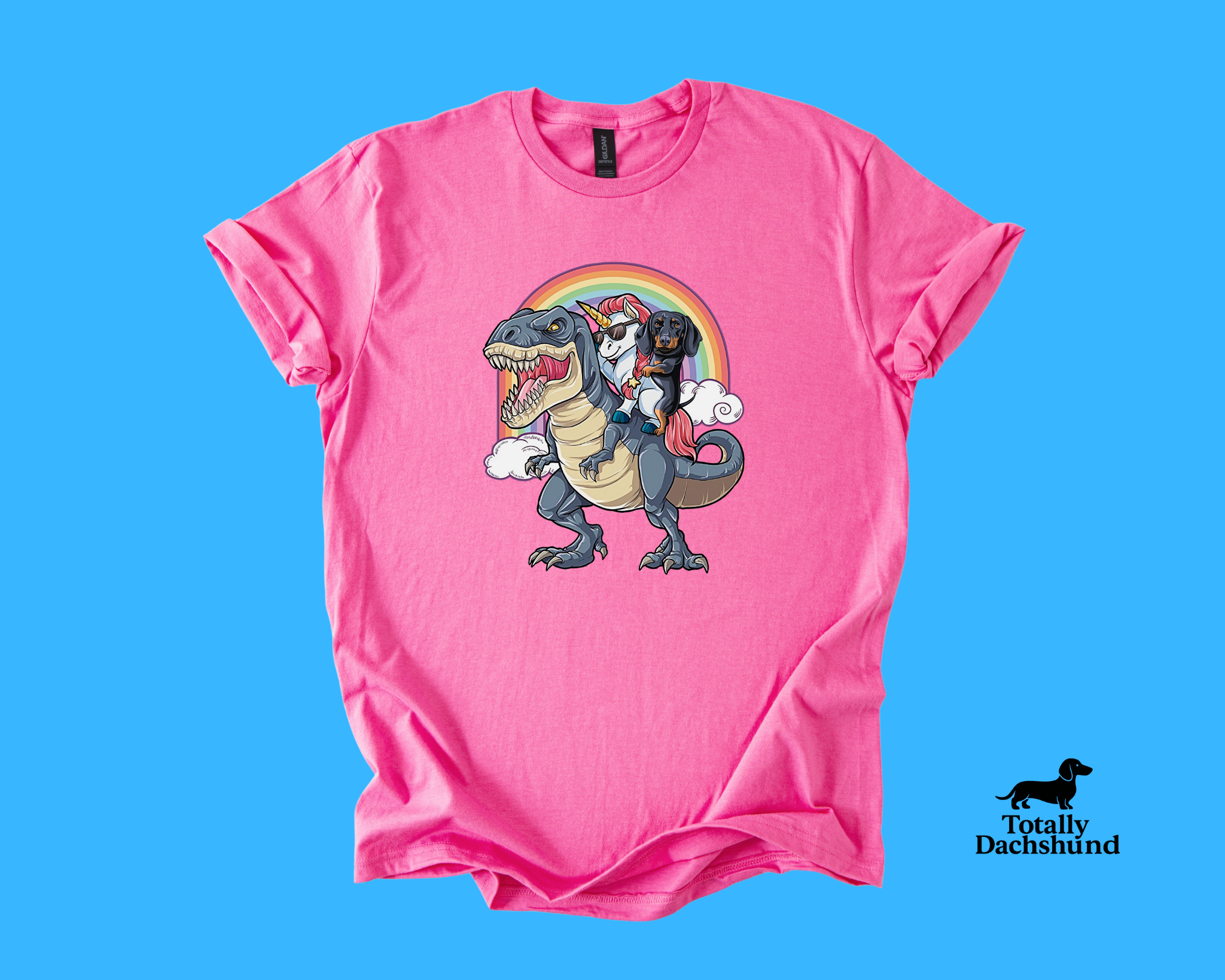 Funny dachshund riding a unicorn with sunglasses on a T-Rex under a rainbow – pink novelty dog shirt